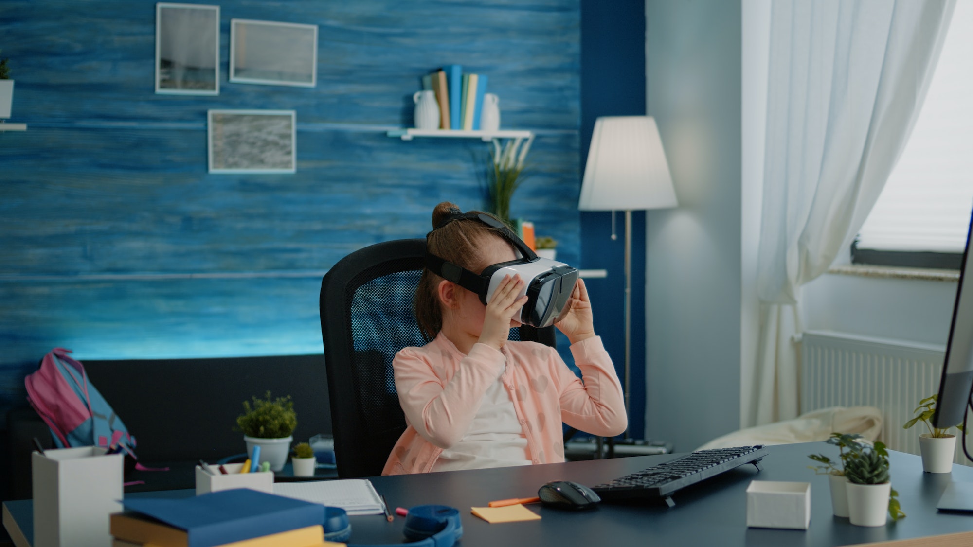 Little schoolgirl using vr glasses for virtual reality learning