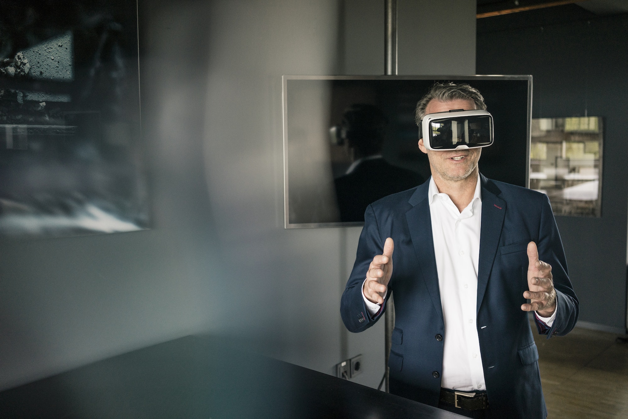 Mature businessman wearing VR glasses in office